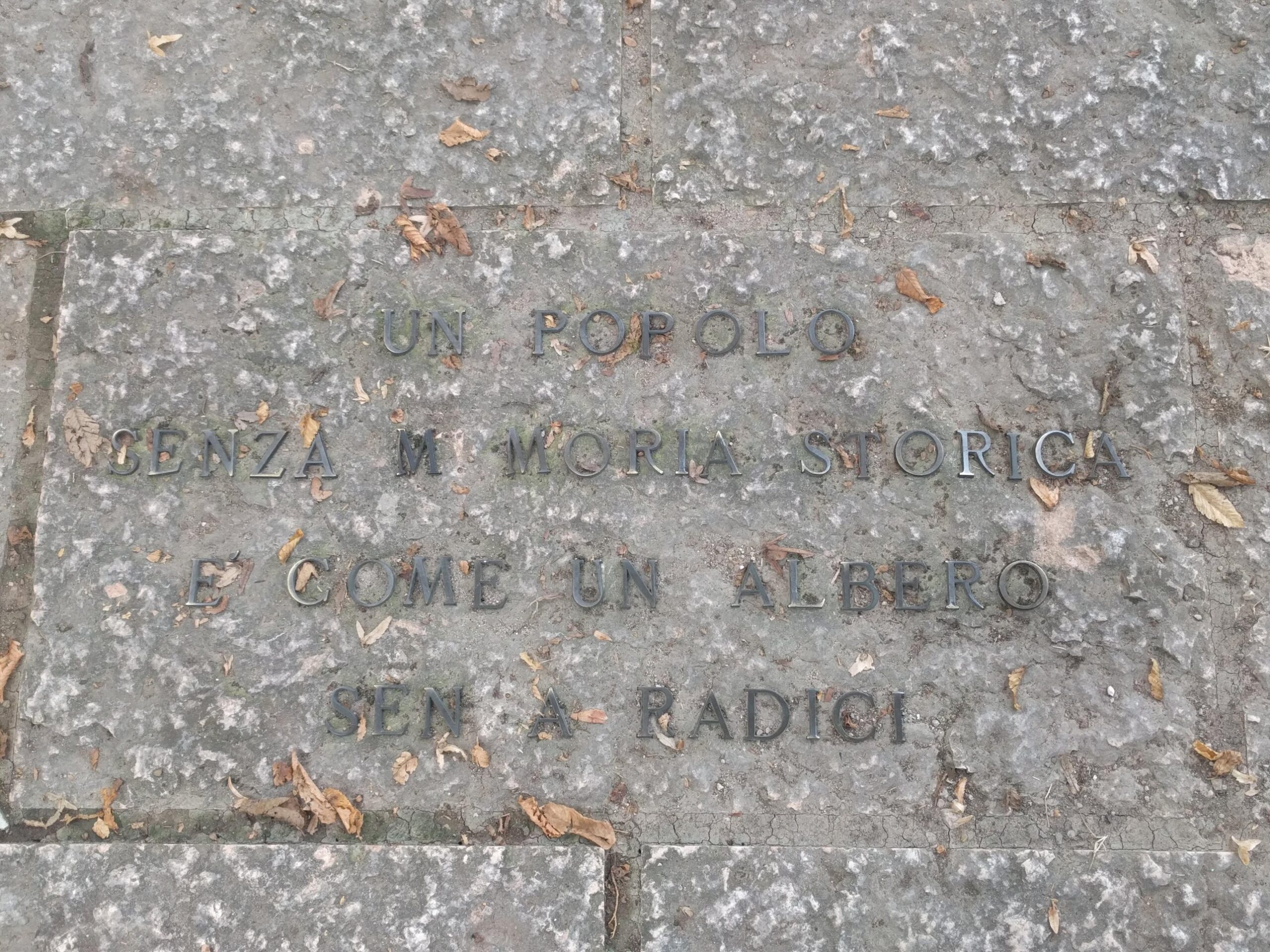 Lapide con la scritta: un popolo senza memoria storica è come un albero senza radici