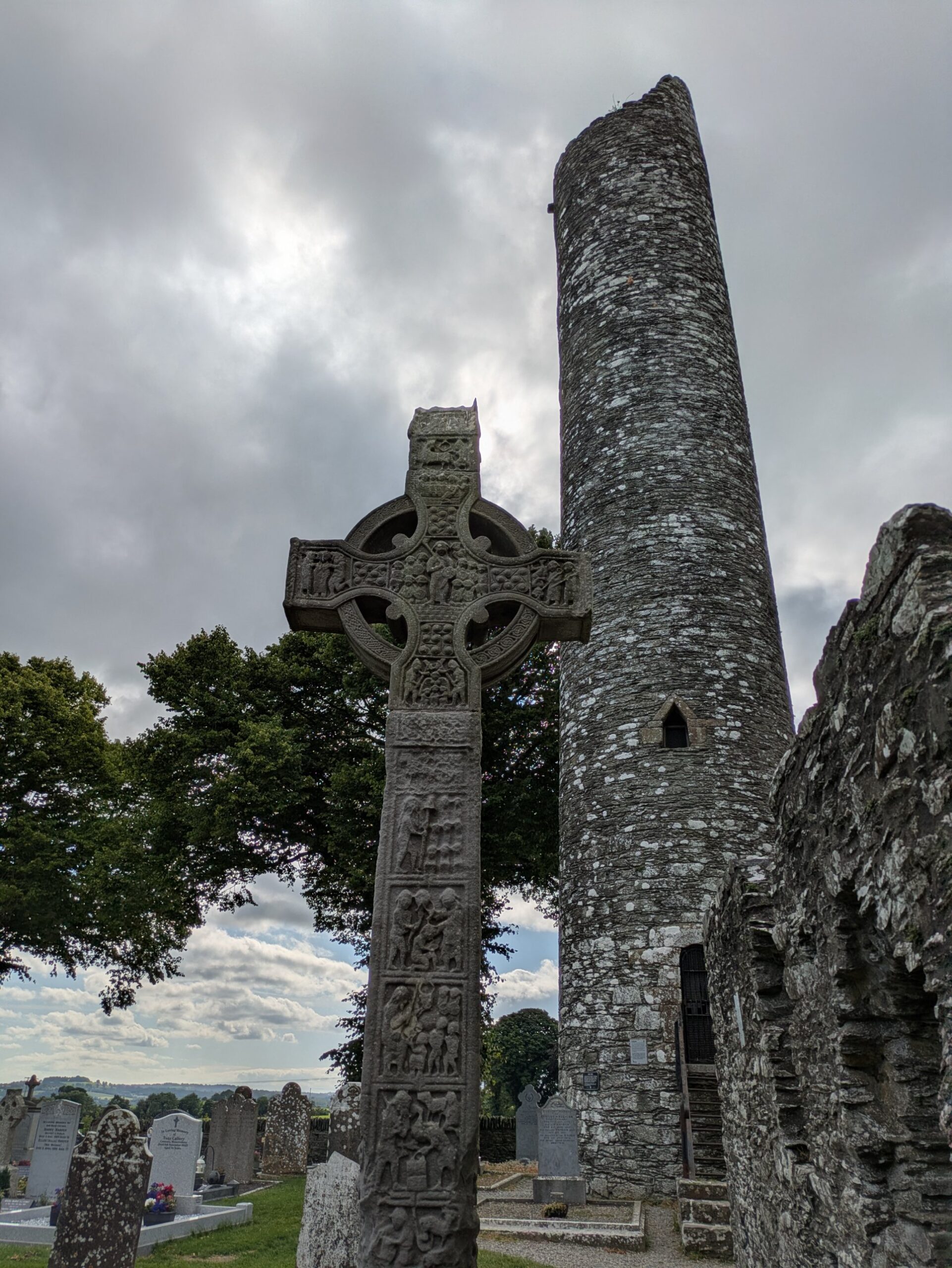 Croce celtica e torre circolare in un antico cimitero irlandese